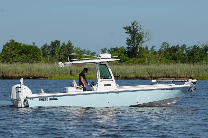 Slide: The Image of 2019 Everglades 273 Center Console boat cruising on a calm river with lush greenery. - 3