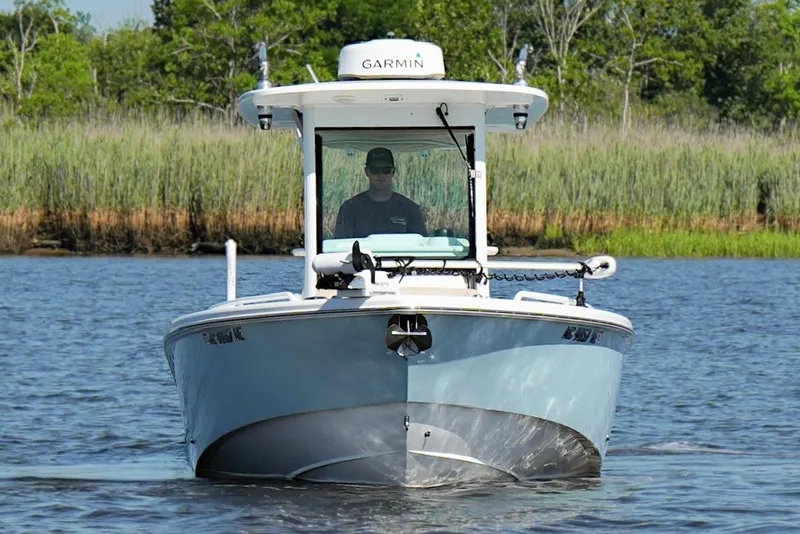 Slide: The Image of 2019 Everglades 273 Center Console boat on water, surrounded by lush greenery. - 9