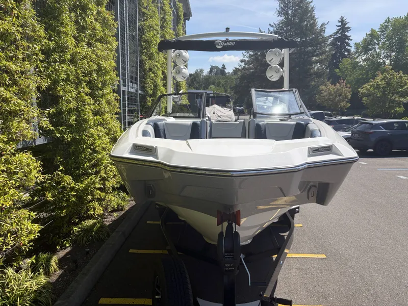 Slide: The Image of 2022 Malibu M220 boat parked on a trailer outdoors. - 3