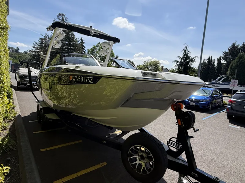 Slide: The Image of 2022 Malibu M220 boat parked on a trailer outdoors. - 4