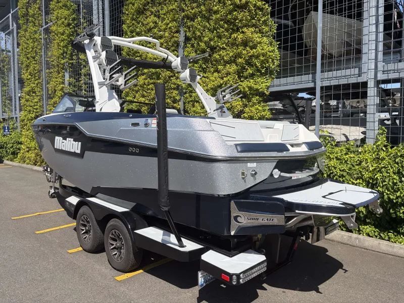 Slide: The Image of 2022 Malibu M220 boat on trailer, parked outdoors. - 7