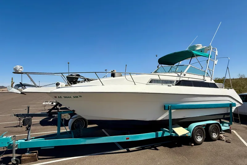 The Image of 1988 Cruisers Yachts 2470 Holiday on trailer under clear blue sky. - 1