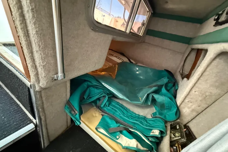 Slide: The Image of Interior cabin of 1988 Cruisers Yachts 2470 Holiday with teal upholstery and storage items. - 15