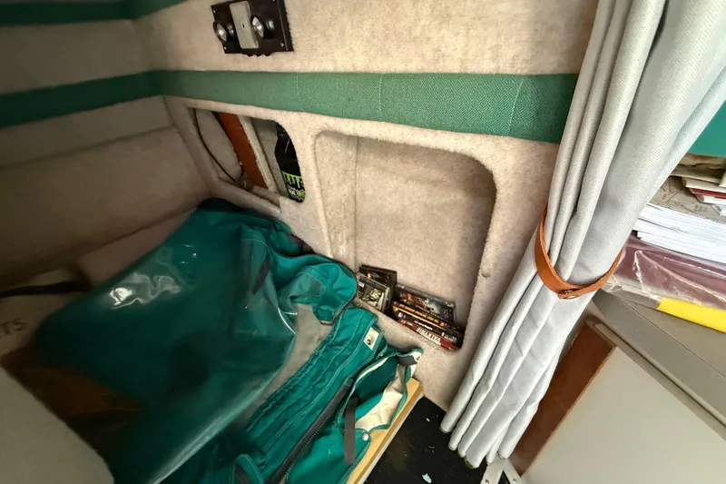 Slide: The Image of Interior of 1988 Cruisers Yachts 2470 Holiday with storage compartments and teal fabric accents. - 16