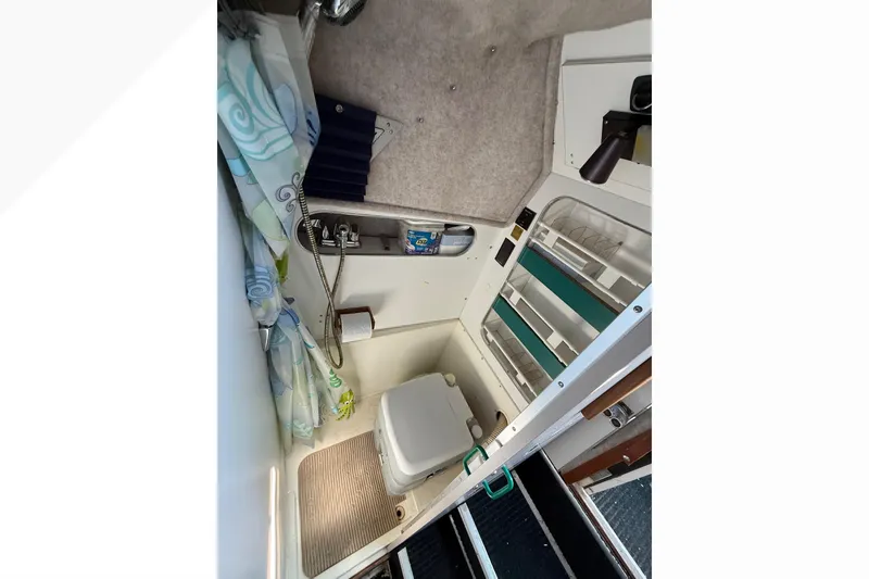 Slide: The Image of Interior of 1988 Cruisers Yachts 2470 Holiday, featuring compact bathroom with toilet and sink. - 17