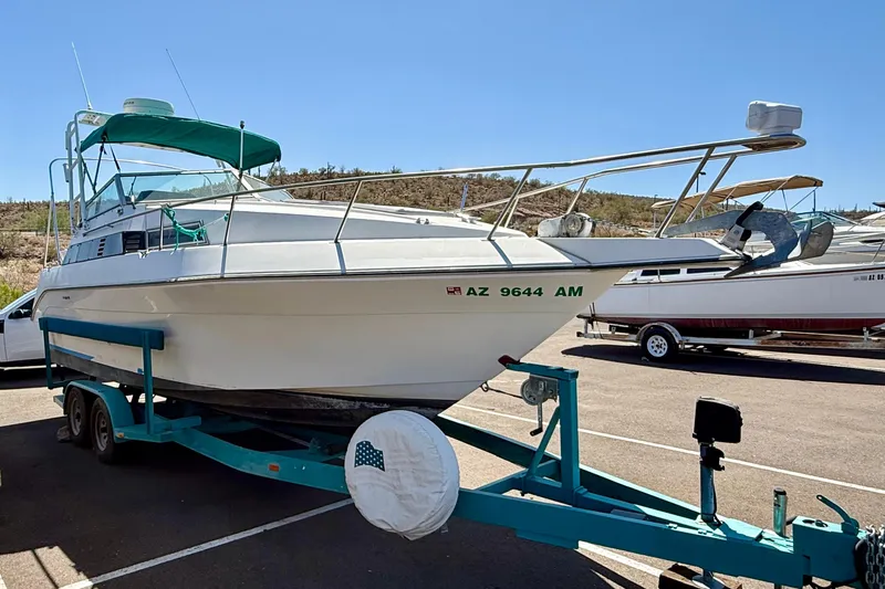 Slide: The Image of 1988 Cruisers Yachts 2470 Holiday boat on trailer in sunny parking lot. - 2