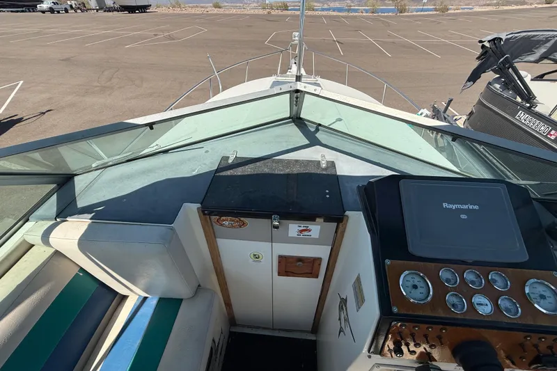 Slide: The Image of 1988 Cruisers Yachts 2470 Holiday dashboard with Raymarine navigation system in a parking lot. - 24
