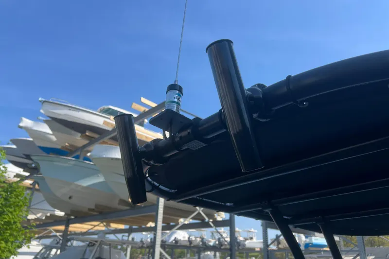 Slide: The Image of 2023 Inmar 600R-PT boat detail with rod holders, docked under clear blue sky. - 12