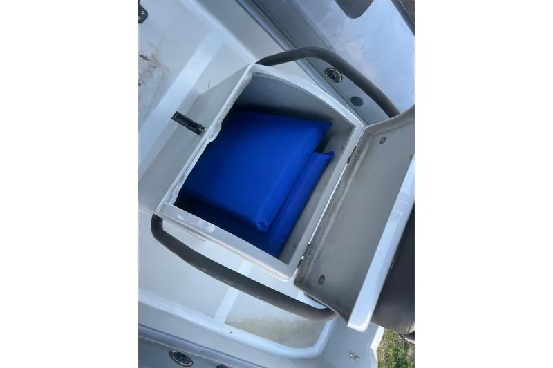 Slide: The Image of Open storage compartment on 2023 Inmar 600R-PT boat with blue cushion inside. - 15