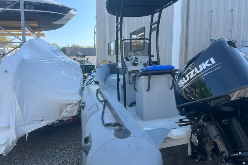 Slide: The Image of 2023 Inmar 600R-PT boat with Suzuki outboard motor in storage facility. - 2