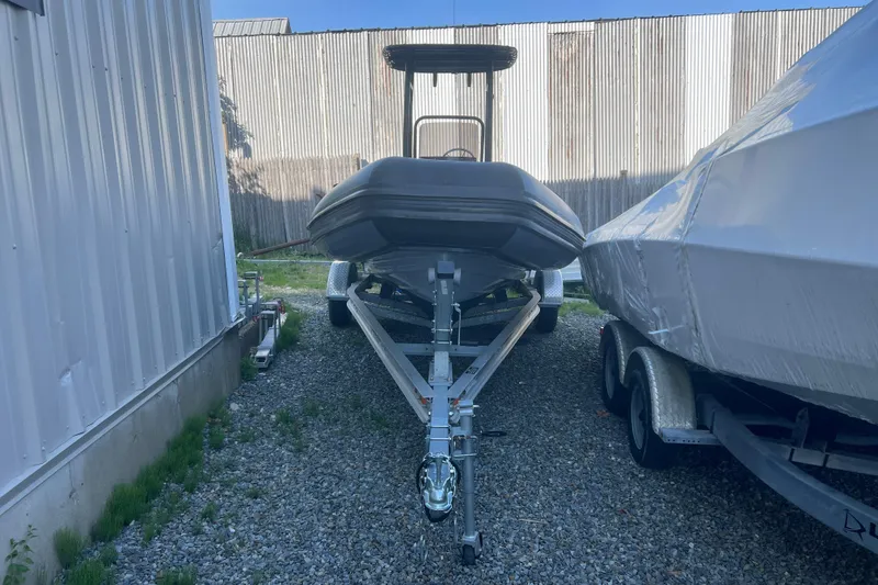 Slide: The Image of 2023 Inmar 600R-PT boat on trailer, parked between buildings on gravel. - 4