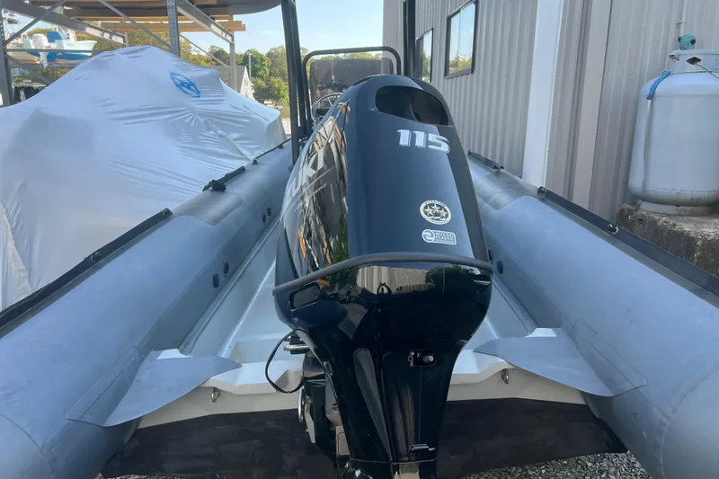 Slide: The Image of 2023 Inmar 600R-PT boat with Suzuki 115 outboard motor, docked near a storage facility. - 5