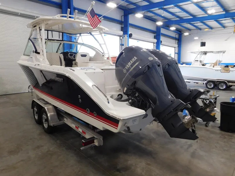 Slide: The Image of 2022 Pursuit DC 266 Dual Console boat with Yamaha engines in warehouse. - 2