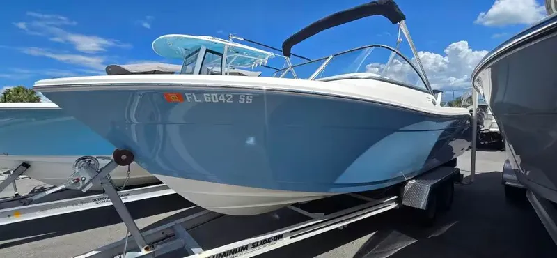 The Image of 2020 Cobia 220 Dual Console boat on trailer, blue sky. - 1