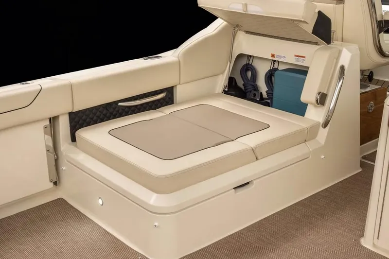 Slide: The Image of Manufacturer Provided Image: 2025 Chris-Craft Calypso 32 boat interior with cushioned seating and storage compartment. - 7