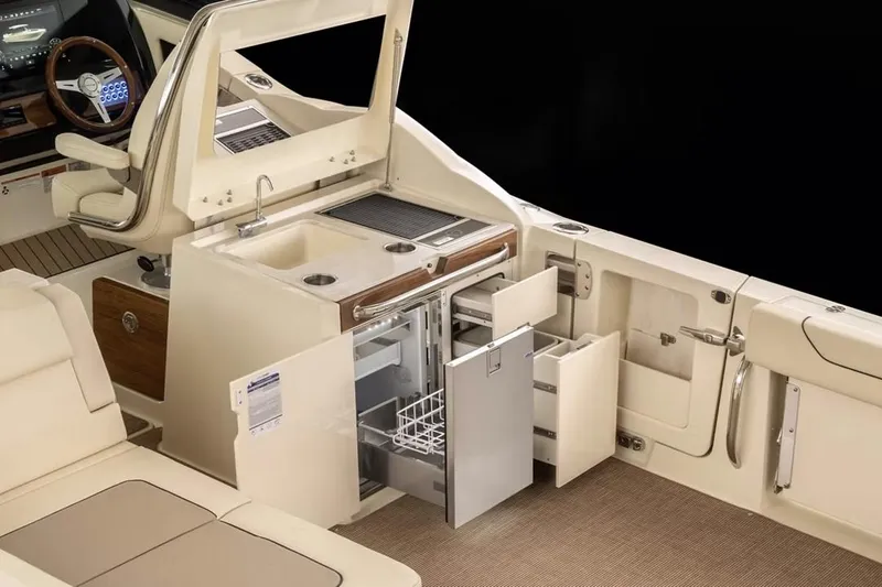 Slide: The Image of Manufacturer Provided Image: Luxurious 2025 Chris-Craft Calypso 32 boat interior with kitchenette and storage. - 9