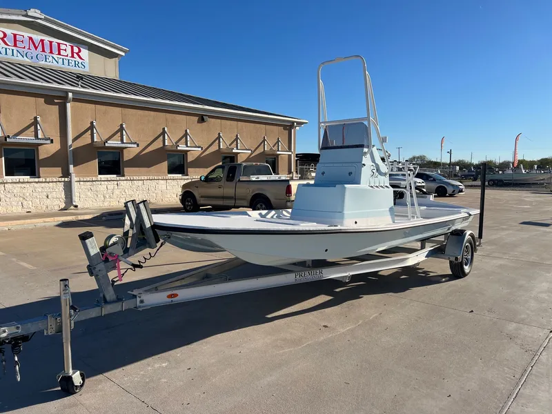 Slide: The Image of 2026 Shoalwater 19' Catamaran on trailer outside boating center. - 3