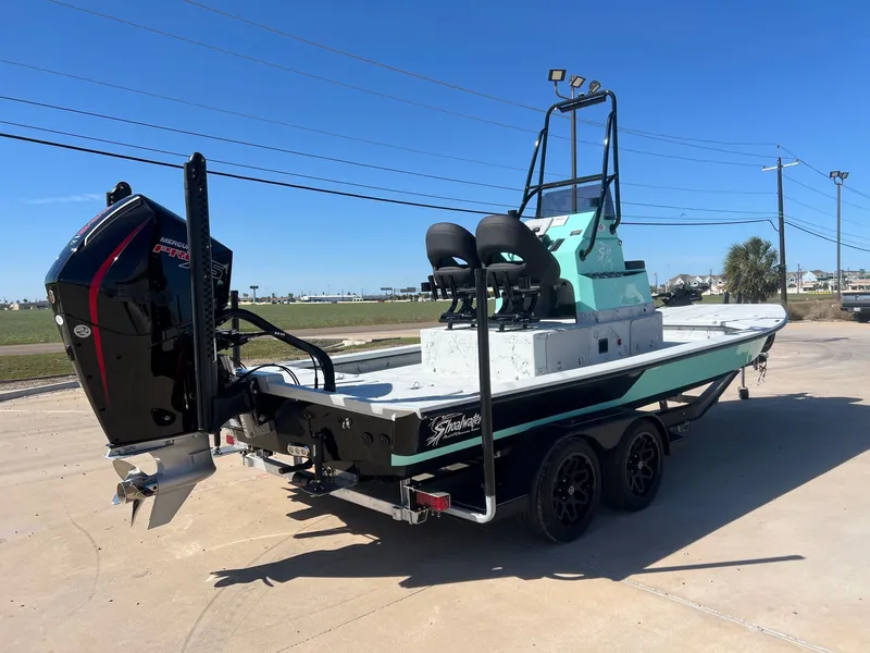 Slide: The Image of 2026 Shoalwater 23' Catamaran on trailer, outboard motor, blue sky. - 8