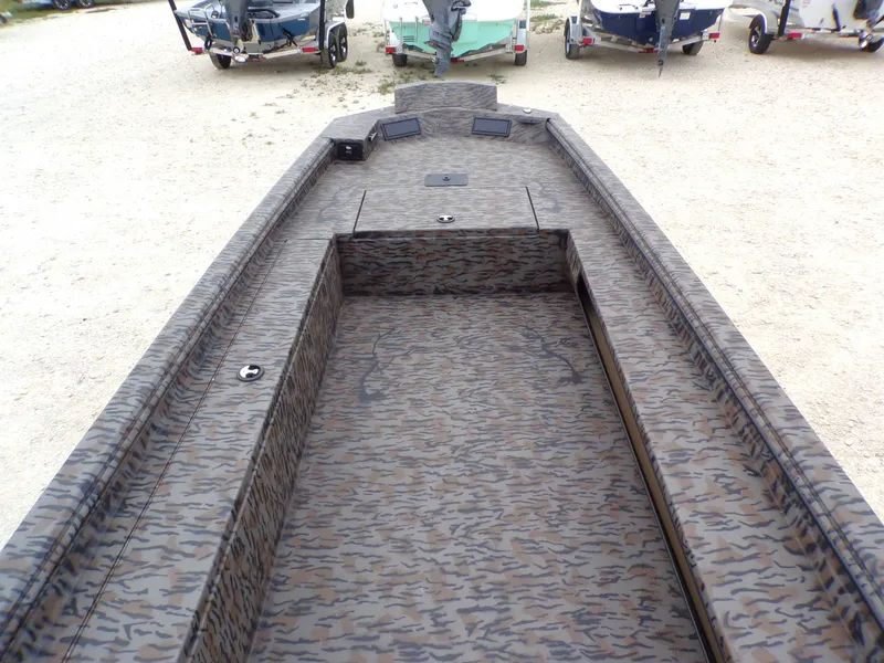 Slide: The Image of 2026 Xpress Bayou 180 boat with camouflage pattern on gravel lot. - 17