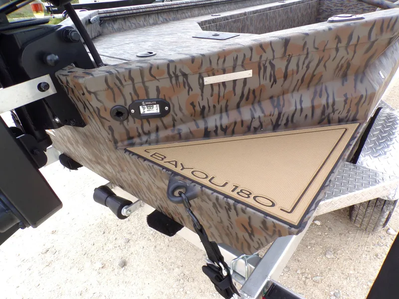 Slide: The Image of 2026 Xpress Bayou 180 boat with camouflage pattern and trailer. - 24