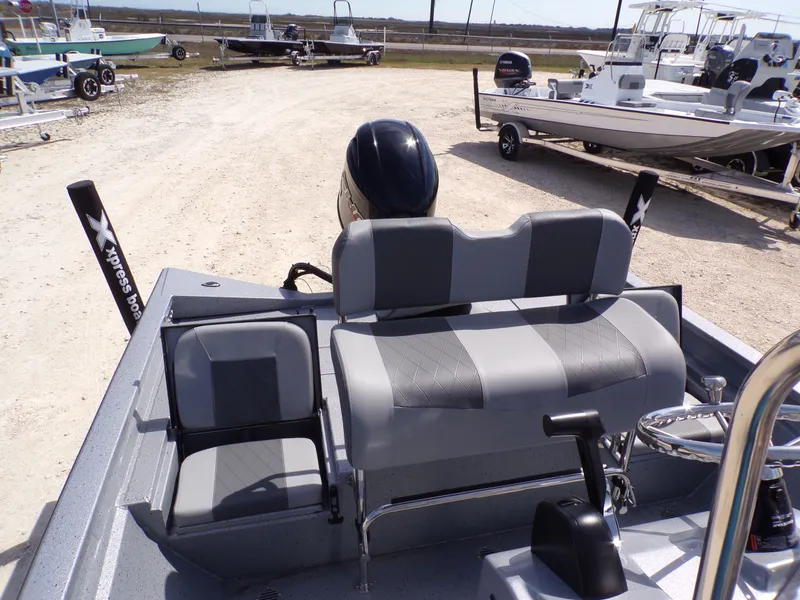 Slide: The Image of 2025 Xpress H20B Bay boat with gray seating outdoors. - 18