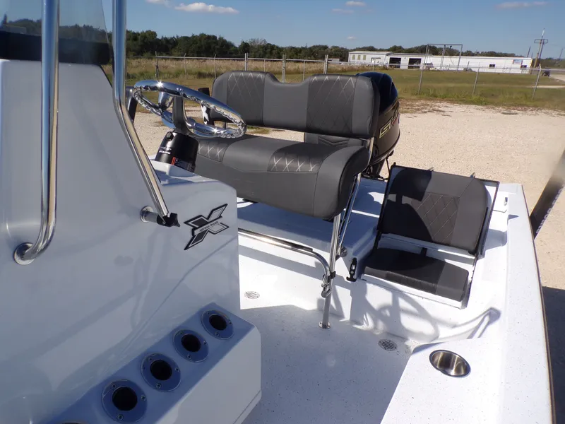 Slide: The Image of 2026 Xpress H20B Bay boat cockpit with steering wheel and seats. - 19