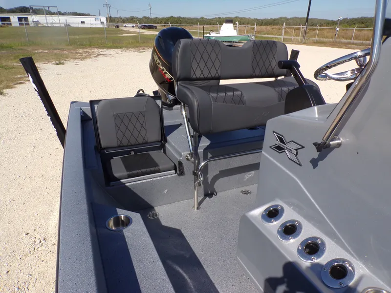 Slide: The Image of 2026 Xpress H20B Bay boat with gray seats and steering console. - 19