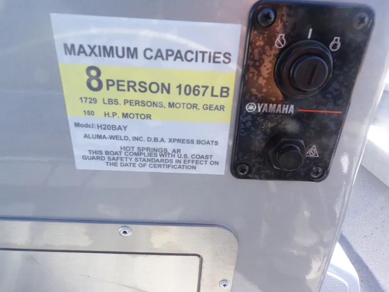 Slide: The Image of Xpress H20B Bay 2026 boat capacity label, 8 persons, 1067 lb, Yamaha control. - 24