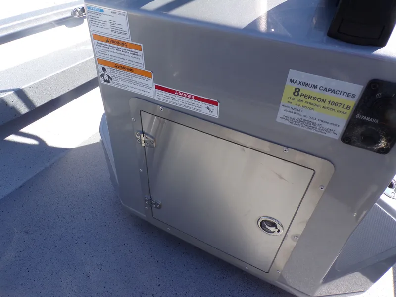 Slide: The Image of Xpress H20B Bay 2026 boat console with warning labels and capacity sign. - 25
