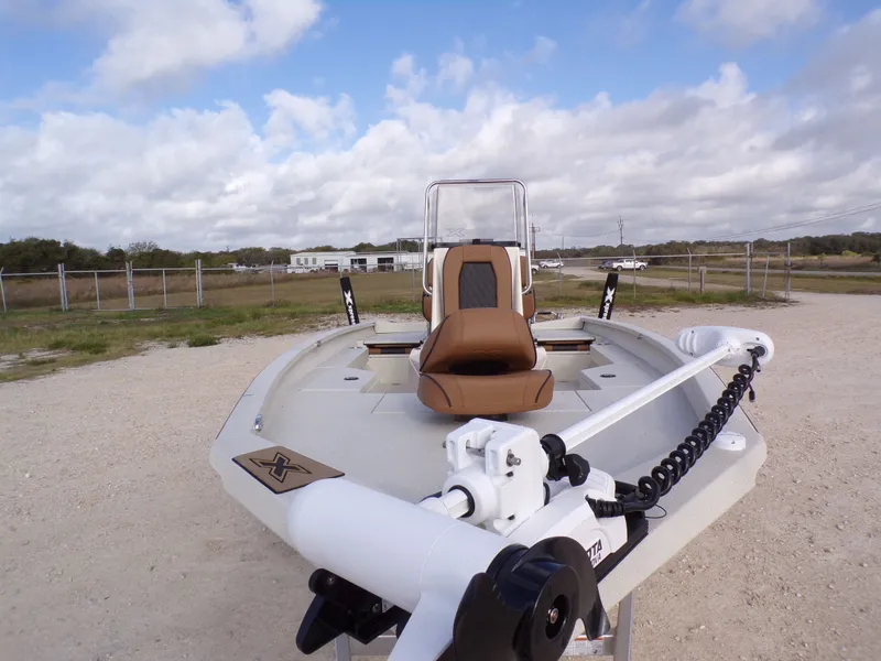 Slide: The Image of 2026 Xpress H20BAY boat on gravel surface under cloudy sky. - 3