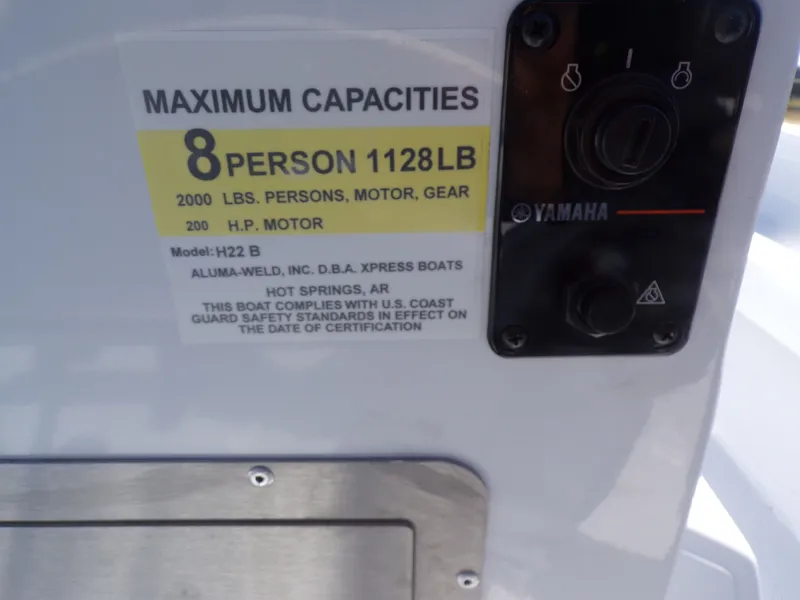 Slide: The Image of Xpress H22B Bay 2026 boat capacity label, 8 persons, 1128 pounds. - 21