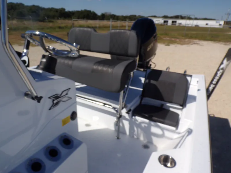 Slide: The Image of 2026 Xpress H22B Bay boat with gray seats and steering console. - 24