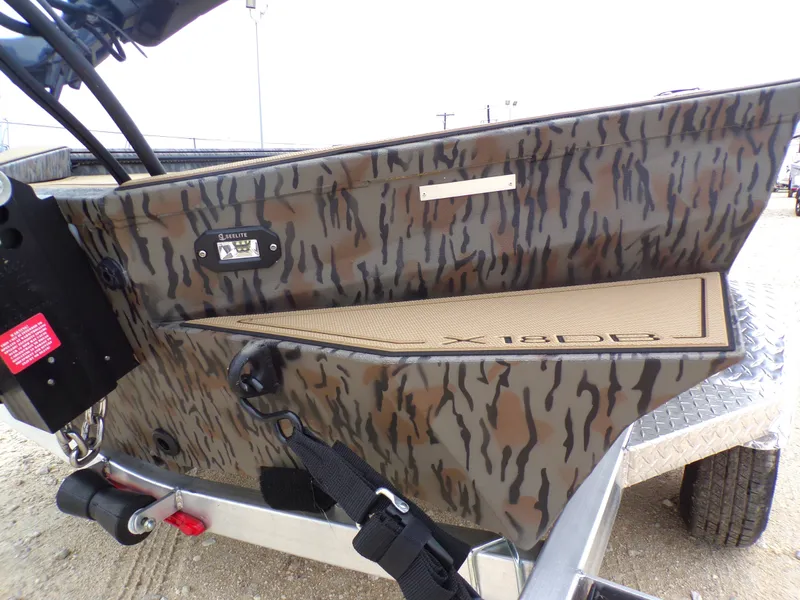 Slide: The Image of 2026 Xpress X18DB boat with camouflage pattern on trailer. - 26