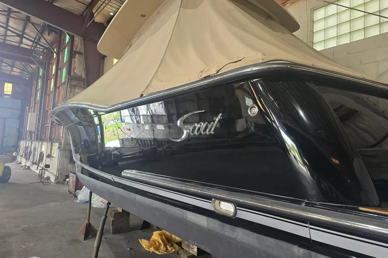 Slide: The Image of 2015 Scout 320 LXF boat in a warehouse, covered and elevated on blocks. - 10