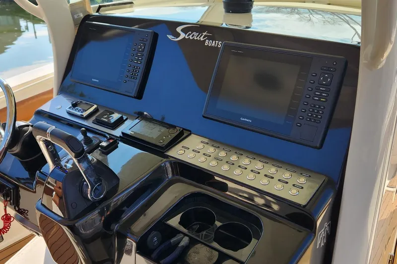 Slide: The Image of 2015 Scout 320 LXF boat dashboard with Garmin navigation system and controls. - 2