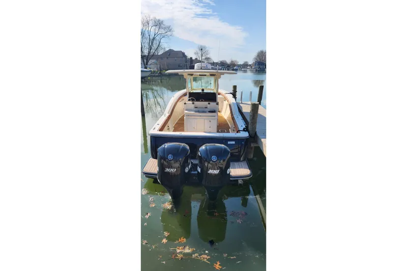 Slide: The Image of 2015 Scout 320 LXF boat docked with dual outboard engines on a sunny day. - 4
