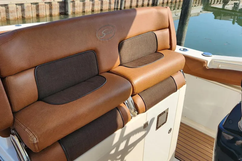 Slide: The Image of Luxurious brown seating on a 2015 Scout 320 LXF boat, dockside view. - 5