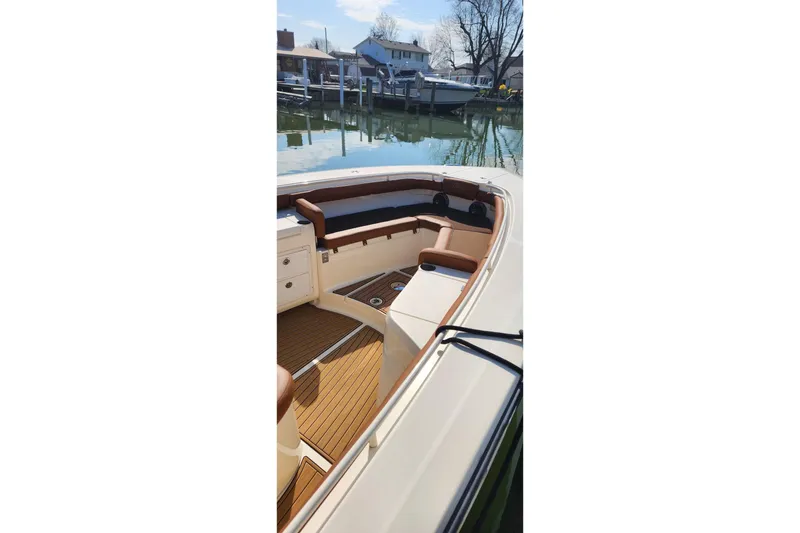 Slide: The Image of 2015 Scout 320 LXF boat interior with brown seating and wooden deck. - 7