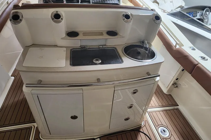 Slide: The Image of 2015 Scout 320 LXF boat interior with sink and storage area. - 8