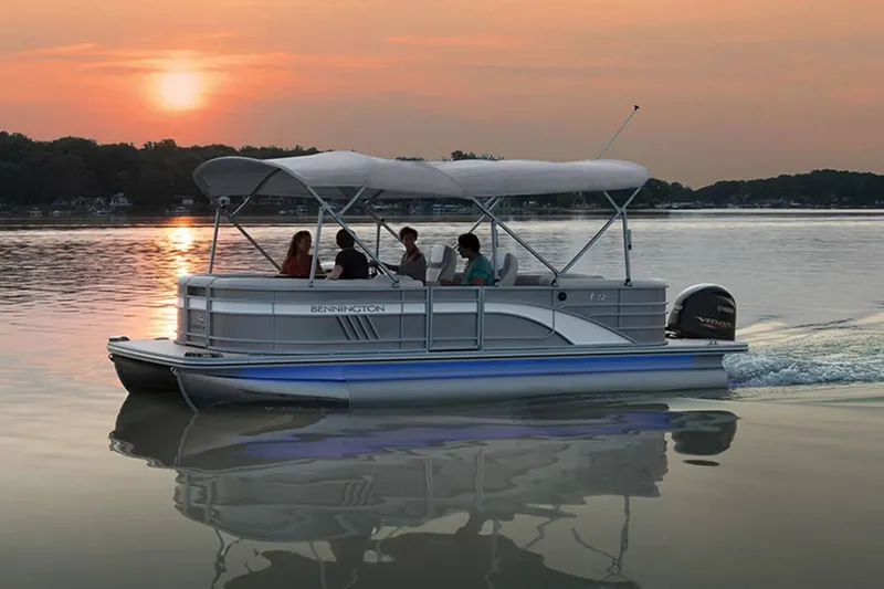 Slide: The Image of 2022 Bennington 23 LSR pontoon boat on water at sunset. - 24