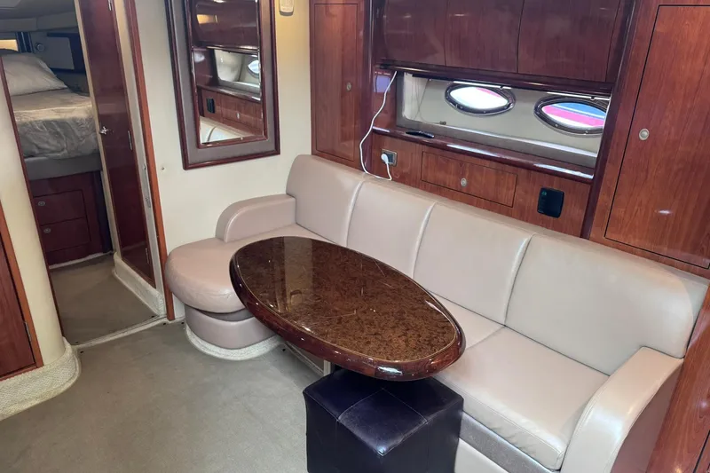 Slide: The Image of Interior of 2004 Sea Ray 390 Sundancer yacht with beige seating and wooden table. - 11