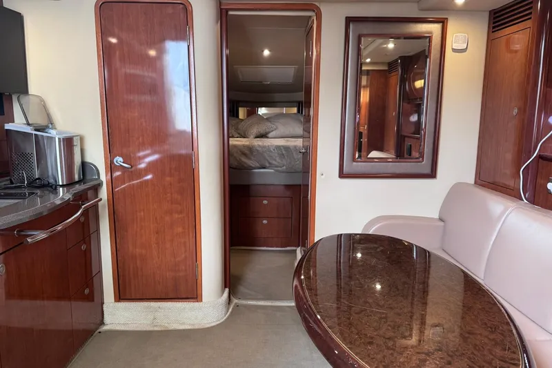 Slide: The Image of Interior of 2004 Sea Ray 390 Sundancer yacht with wood cabinetry and cozy seating area. - 13