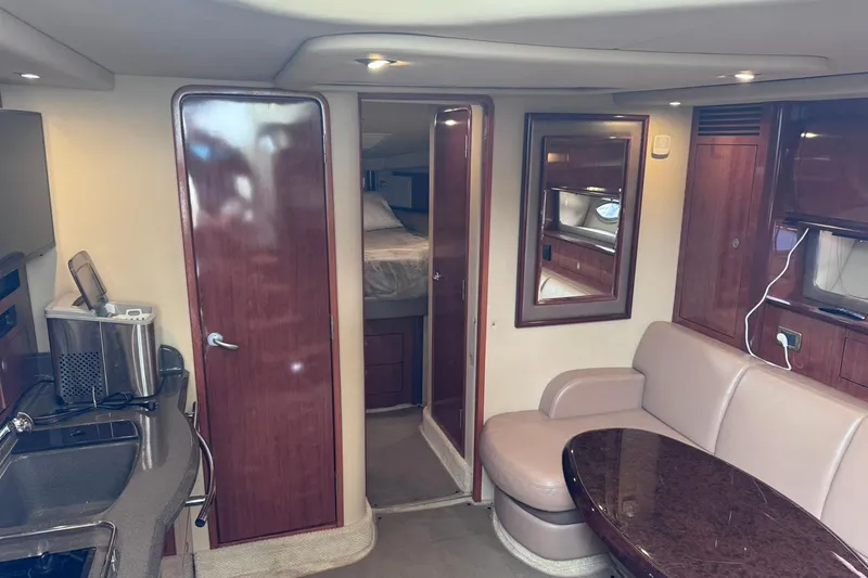 Slide: The Image of Interior of 2004 Sea Ray 390 Sundancer yacht with kitchenette, seating, and wood finishes. - 20