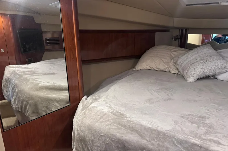 Slide: The Image of Interior cabin of 2004 Sea Ray 390 Sundancer with cozy bed and wooden accents. - 22