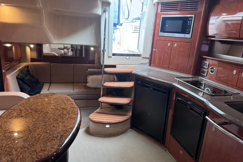 Slide: The Image of Luxurious interior of a 2004 Sea Ray 390 Sundancer yacht with kitchen and seating area. - 24