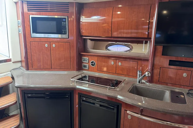Slide: The Image of Luxurious 2004 Sea Ray 390 Sundancer yacht kitchen with wood cabinetry and modern appliances. - 29