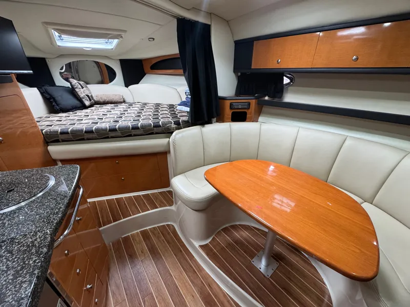 Slide: The Image of Interior of 2008 Chaparral 310 Signature yacht with sleeping area and dining table. - 8