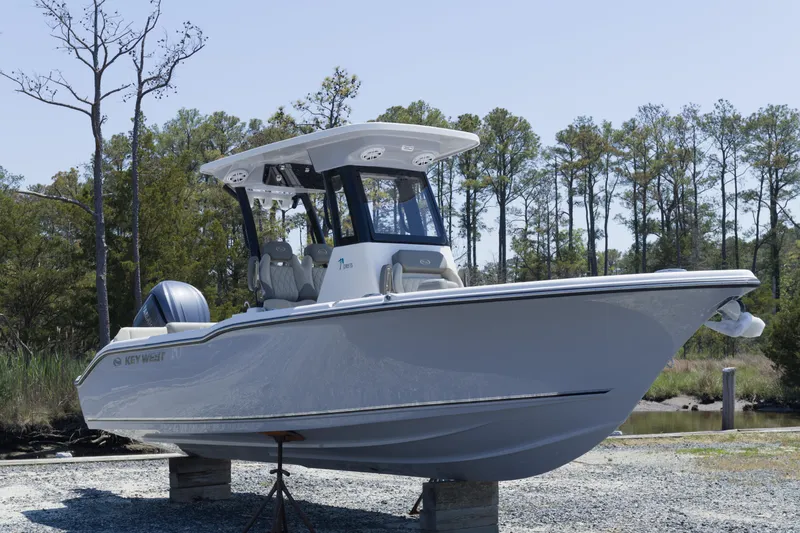 Slide: The Image of 2026 Key West 249 FS boat on display outdoors, surrounded by trees. - 1