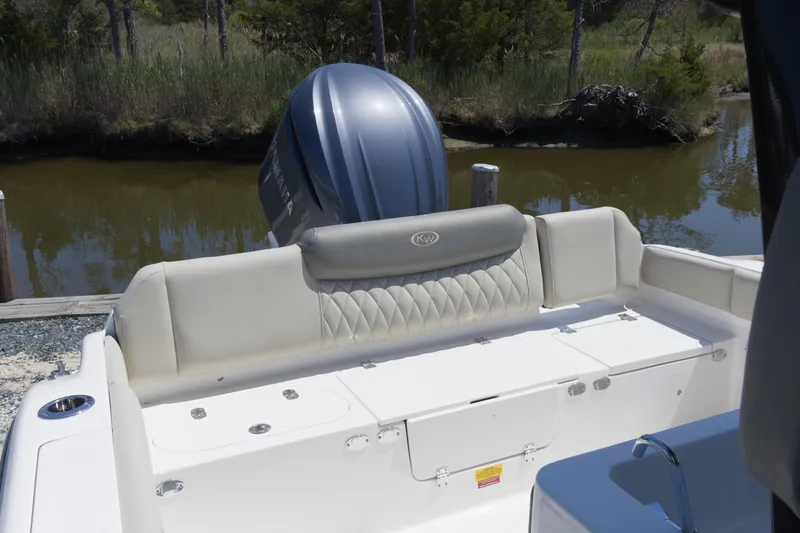 Slide: The Image of 2026 Key West 249 FS boat with cushioned seating and outboard motor by a riverbank. - 7