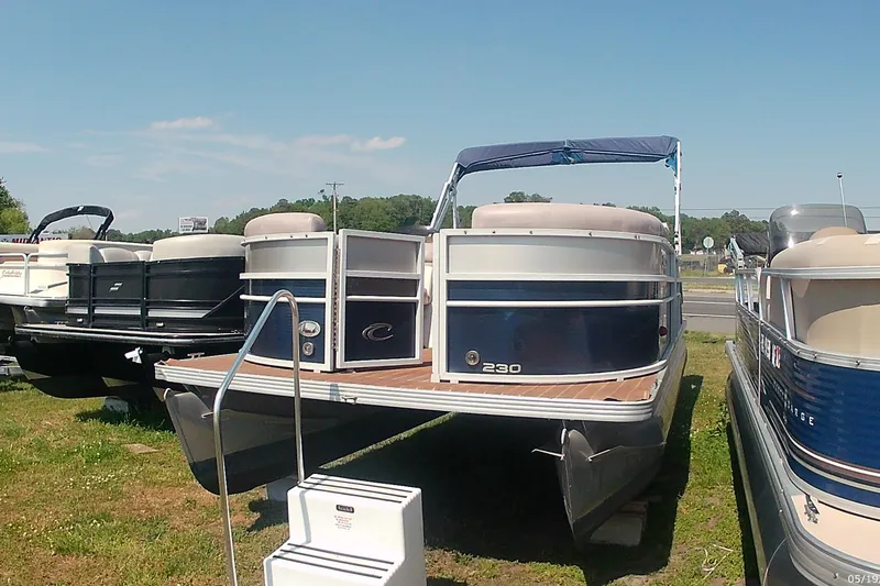 The Image of 2015 Crest 230 bar pontoon boat displayed outdoors on grass. - 1